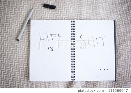 Suicide, depression and a note with handwriting from suicidal thoughts. Mental health, sadness and a cry for help in notebook on a bed. Stress, anxiety and a sad message in writing that life is shit Suicide, depression and a note with handwriting from suicidal thoughts. Mental health, sadness and a cry for help in notebook on a bed. Stress, anxiety and a sad message in writing that life is shit 111369047