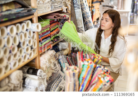 Woman choosing rug at household goods shop 111369165