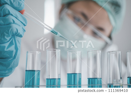 Female researchers are experimenting with pipette dropping a sample into a test tube in an experiment research in laboratory... Female researchers are experimenting with pipette dropping a sample into a test tube in an experiment research in laboratory... 111369410