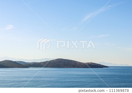 Sea, mountains and blue sky over horizon in the morning. Tranquil seascape and coastal nature background Sea, mountains and blue sky over horizon in the morning. Tranquil seascape and coastal nature background 111369878