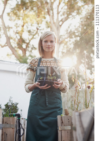 Gardening, morning and portrait of woman with plants for landscaping, planting flowers and growth. Agriculture, nature and face of person outdoors for environment, ecology and nursery in garden 111370113