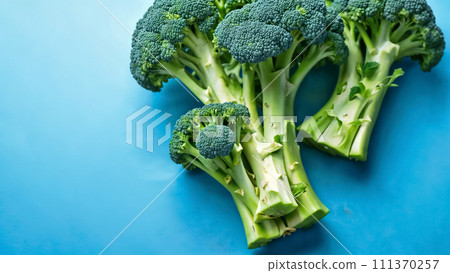 Fresh green broccoli on blue background top view Fresh green broccoli on blue background top view 111370257