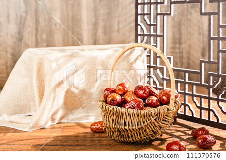 Dates in basket on wooden table 111370576