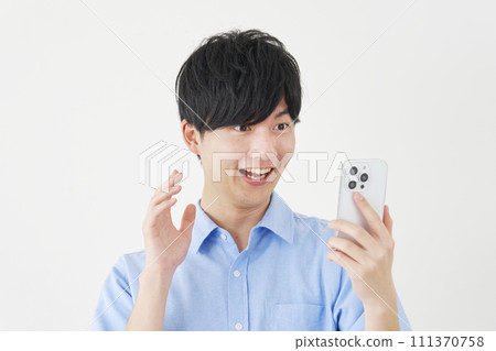 Surprised man looking at smartphone, white background Surprised man looking at smartphone, white background 111370758