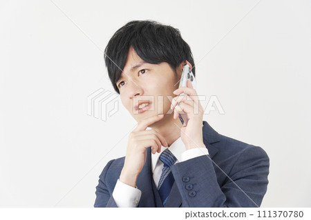 Businessman calling on smartphone while worried, white background 111370780