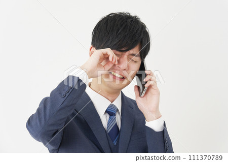 Businessman crying and calling on smartphone, white background 111370789
