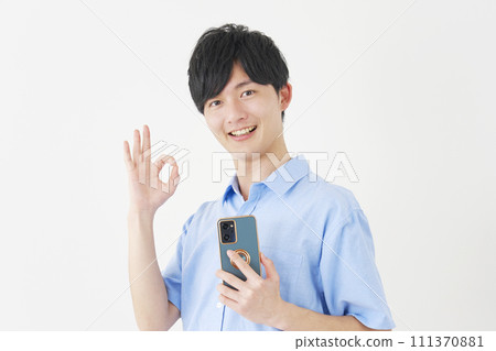 A man holding a smartphone and giving an OK sign, white background 111370881