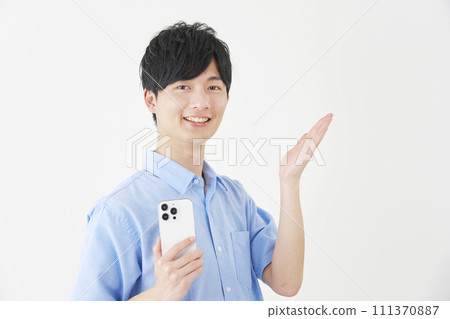 A man holding a smartphone and pointing to the right with his palm, white background A man holding a smartphone and pointing to the right with his palm, white background 111370887