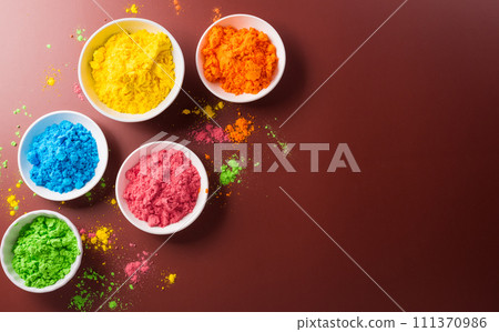 Happy Holi decoration, the indian festival.Top view of colorful holi powder on dark background. Happy Holi decoration, the indian festival.Top view of colorful holi powder on dark background. 111370986