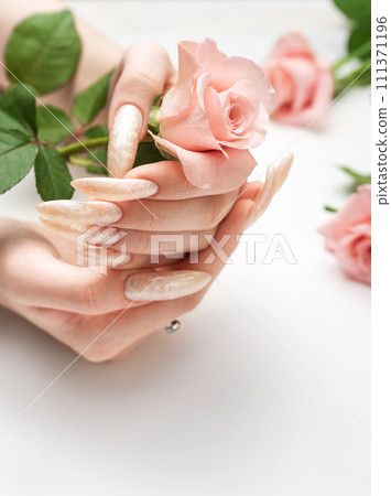 Female Hands on a white background with beautiful pearl manicure.Hands on a brown background and beautiful pearl manicure Female Hands on a white background with beautiful pearl manicure.Hands on a brown background and beautiful pearl manicure 111371196