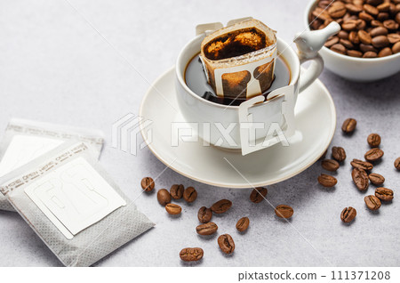 Drip coffee bag with ground coffee in cup Drip coffee bag with ground coffee in cup 111371208