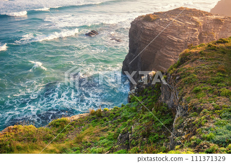 Seascape on a sunny day. Beautiful quiet bay. Rocky sea coast at sunrise. Beach Praia de Augas Santas in Ribadeo. Galicia Spain Europe 111371329