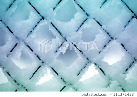 Abstract winter background. Snow on the metal grid. Abstract winter background. Snow on the metal grid. 111371438