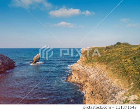 Seascape on a sunny day. Rocky sea coast. Aerial view of Buelna Bay and El Picon. Buelna, Asturias, Spain Seascape on a sunny day. Rocky sea coast. Aerial view of Buelna Bay and El Picon. Buelna, Asturias, Spain 111371542