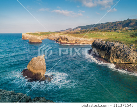 Seascape on a sunny day. Rocky sea coast. Aerial view of Buelna Bay and El Picon. Buelna, Asturias, Spain 111371543