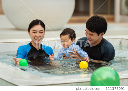 happy family. father and mother with small daughter in swimming pool. happy family. father and mother with small daughter in swimming pool. 111372091