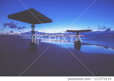 Sunshades on the evening beach after sunset. Seascape at night. Caesarea, Israel Sunshades on the evening beach after sunset. Seascape at night. Caesarea, Israel 111373214