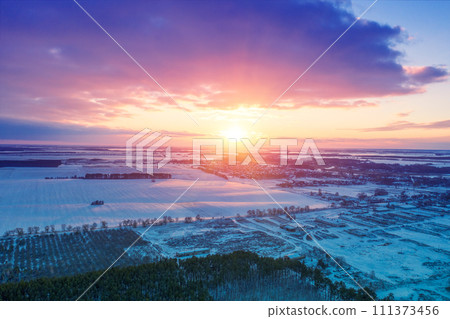 View from above of winter snowy countryside at sunset View from above of winter snowy countryside at sunset 111373456