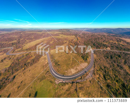 Winding highway in the autumn mountains. Drone view. Beautiful natural landscape. The Carpathians. Ukraine Winding highway in the autumn mountains. Drone view. Beautiful natural landscape. The Carpathians. Ukraine 111373889