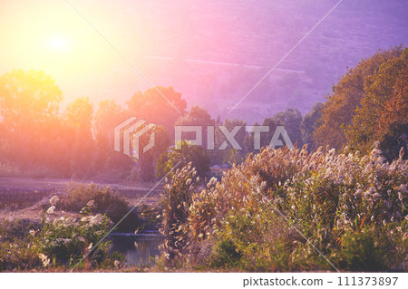 Mountain landscape in the evening. Beautiful lake against mountains. The Hula Valley in northern Israel at sunset 111373897