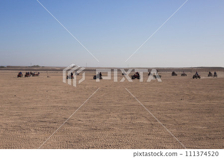 Group of tourists on ATVs on safari road Group of tourists on ATVs on safari road 111374520