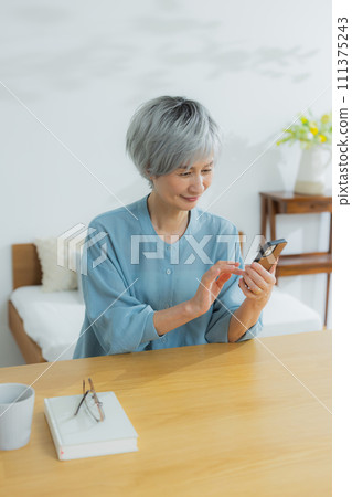 Senior female using a smartphone 111375243