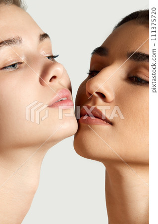 Close-up portrait of beautiful tender girls with different skin tones posing against white studio background. Foundation Close-up portrait of beautiful tender girls with different skin tones posing against white studio background. Foundation 111375720