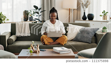 Black woman on sofa, smile and typing on laptop for remote work, social media or blog post research in home. Happy girl on couch with computer checking email, website or online chat in living room. 111375898