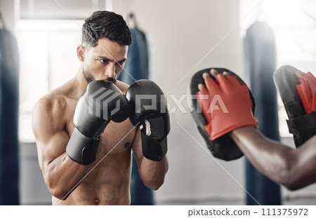 Boxing gym, fighting pad and man training with athlete coach for a fitness cardio exercise session. Strength, focus and fighter workout for punch technique with professional sports equipment. 111375972