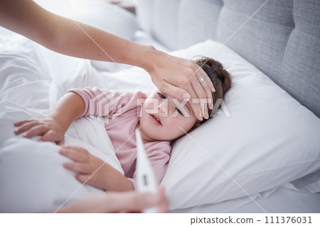 Sick, virus and fever child bedroom with mother feeling hot forehead, thermometer temperature and healthcare problem test results. Young girl kid resting at home for medical symptoms and covid risk 111376031