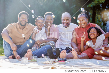 Portrait, happy black family and picnic in summer happiness and bubbles in nature fun and bonding time. Joyful African people smile together in group generations and moments relaxing in the outdoors 111376077
