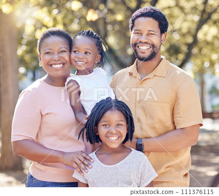Portrait of a happy black family in nature in a garden for summer picnic while on holiday. Smile, love and african mother and father with their girl children in outdoor park on a countryside vacation Portrait of a happy black family in nature in a garden for summer picnic while on holiday. Smile, love and african mother and father with their girl children in outdoor park on a countryside vacation 111376115