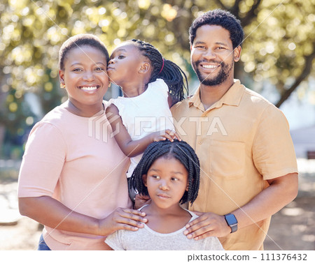 Black family, outdoor fun and smile of parents bonding and spending free time with their children on a sunny day. Portrait of happy man and woman standing in a park or nature with their cute girls 111376432