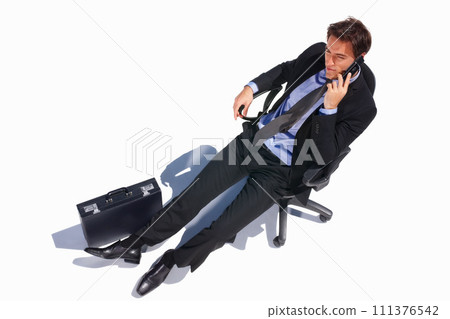 Business man, relax and phone call of a corporate professional in a chair with communication in studio. Worker, male employee and suit with mobile networking and white background with job and career 111376542