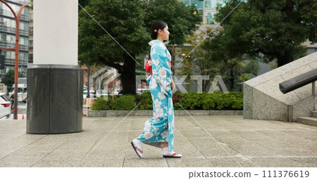 Japan, woman in a city and walking with traditional clothes, travel and fresh air with wellness, healthy and peace. Person, freedom and girl with culture, movement and thinking in a street Japan, woman in a city and walking with traditional clothes, travel and fresh air with wellness, healthy and peace. Person, freedom and girl with culture, movement and thinking in a street 111376619