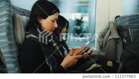 Women, reading and train by smartphone on social media and public transport on metro bullet in japan. Friends, cellphone or diversity on fast vehicle on weekend trip or commute in tokyo on adventure Women, reading and train by smartphone on social media and public transport on metro bullet in japan. Friends, cellphone or diversity on fast vehicle on weekend trip or commute in tokyo on adventure 111377003