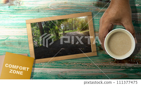 Chalkboard on the table with an outdoor view with comfort zone text on note paper Chalkboard on the table with an outdoor view with comfort zone text on note paper 111377475