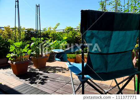Relaxing time with camping outdoor chairs on the roof balcony of the condominium's green garden Relaxing time with camping outdoor chairs on the roof balcony of the condominium's green garden 111377771