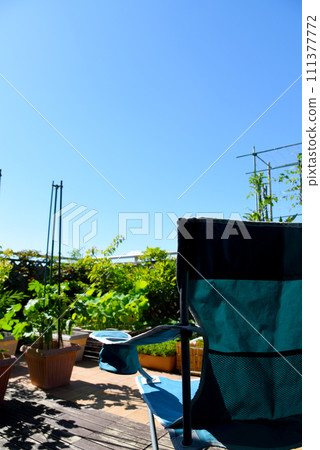 Relaxing time with camping outdoor chairs on the roof balcony of the condominium's green garden 111377772