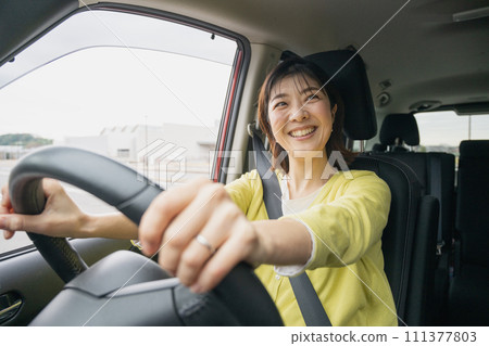 A woman driving a minivan 111377803