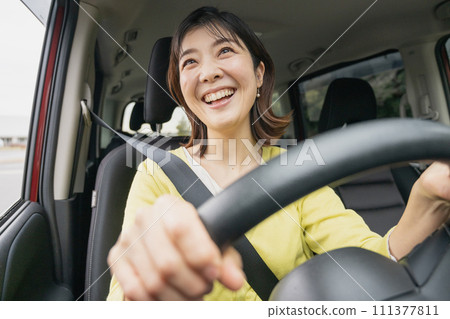 A woman driving a minivan 111377811
