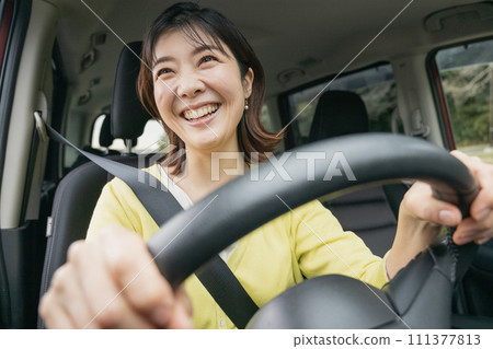 A woman driving a minivan A woman driving a minivan 111377813