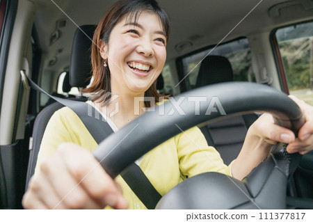 A woman driving a minivan A woman driving a minivan 111377817