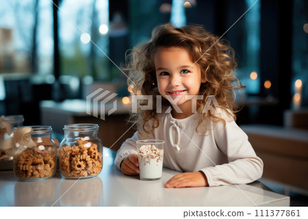 Child girl is sitting at the table and having dinner with yogurt with granola, grain cookies in the kitchen 111377861