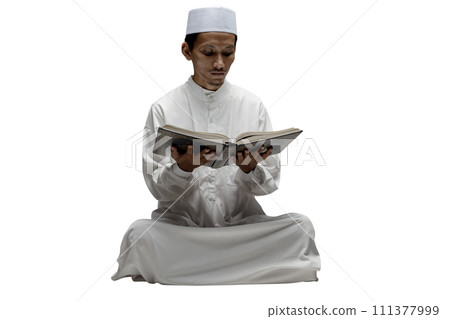 Muslim man sitting and reading the koran Muslim man sitting and reading the koran 111377999
