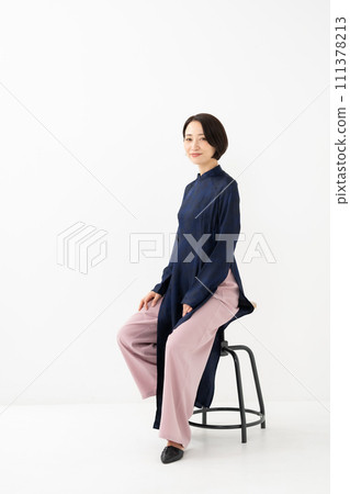 A woman wearing Ao Dai sits down 111378213