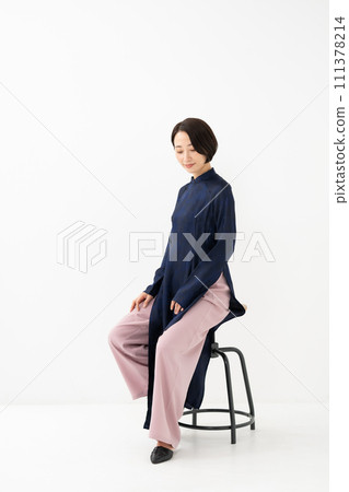 A woman wearing Ao Dai sits down 111378214