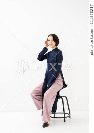 A woman wearing Ao Dai sits down 111378217