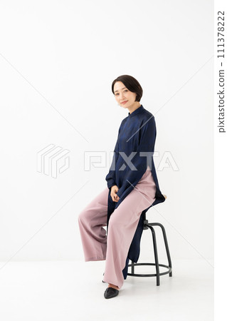 A woman wearing Ao Dai sits down A woman wearing Ao Dai sits down 111378222