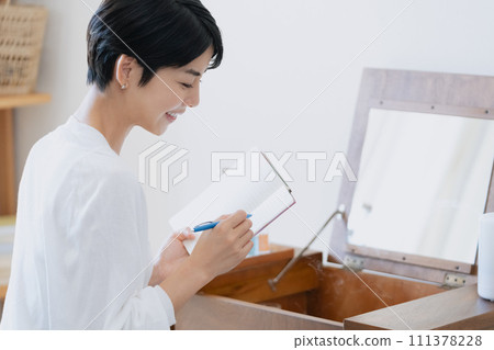 一位女士在她房間的筆記本上寫下她的計劃 111378228